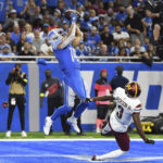 
              Detroit Lions wide receiver Amon-Ra St. Brown (14) makes a touchdown catch against Washington Commanders cornerback William Jackson III (3) during the first half of an NFL football game Sunday, Sept. 18, 2022, in Detroit. (AP Photo/Lon Horwedel)
            