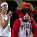 
              Chicago Bulls' Alex Caruso plays pop darts with Benny The Bull during the NBA basketball team's Media Day, Monday, Sept. 26, 2022, in Chicago. (AP Photo/Charles Rex Arbogast)
            
