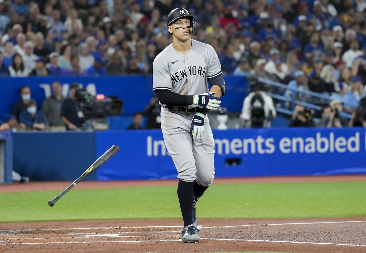 New York Yankees' Aaron Judge tosses his bat as he is walked by Toronto Blue Jays starting pitcher ...