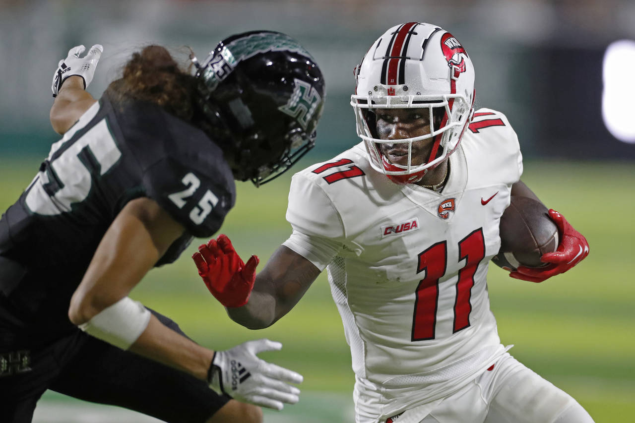 Western Kentucky wide receiver Malachi Corley (11) prepares to fend off Hawaii defensive back Matag...