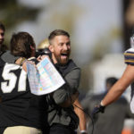 
              Colorado interim head coach Mike Sanford, third from left, celebrates with linebacker Thomas Notarianni, second from left, and tight end Louis Passarello, left, as California offensive lineman Brian Driscoll, right, walks off the field after overtime in an NCAA college football game in at Folsom Field, Saturday, Oct. 15, 2022, in Boulder, Colo. (AP Photo/David Zalubowski)
            