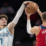 
              Charlotte Hornets guard LaMelo Ball (1) tries to block a shot from Washington Wizards center Kristaps Porzingis in the first half of an NBA preseason basketball game in Charlotte, N.C., Monday, Oct. 10, 2022. (AP Photo/Jacob Kupferman)
            