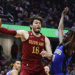 
              Cleveland Cavaliers forward Cedi Osman (16) passes around Orlando Magic center Bol Bol (10) during the first half of a NBA basketball game, Wednesday, Oct. 26, 2022, in Cleveland. (AP Photo/Ron Schwane)
            