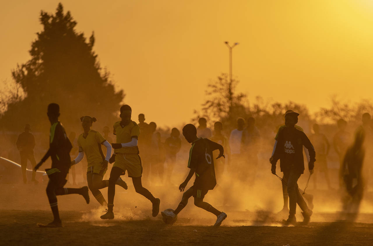 FILE- Young boys play soccer on a dusty field in Duduza, east of Johannesburg, South Africa, June 2...