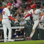
              Philadelphia Phillies' Bryson Stott (5) celebrates with third base coach Dusty Wathan (62) after hitting a home run against the Houston Astros during the eighth inning of a baseball game Monday, Oct. 3, 2022, in Houston. (AP Photo/David J. Phillip)
            