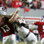 
              North Carolina State quarterback Devin Leary (13) is hit by Florida State's Joshua Farmer (44) while throwing a pass, with lineman Derrick Eason (53) nearby during the second half of an NCAA college football game in Raleigh, N.C., Saturday, Oct. 8, 2022. (AP Photo/Karl B DeBlaker)
            