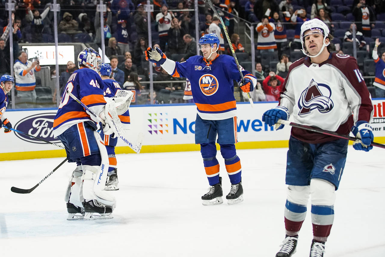 New York Islanders defenseman Scott Mayfield (24) and goaltender Semyon Varlamov (40) celebrate aft...