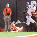 
              Texas wide receiver Xavier Worthy (8) runs past Oklahoma State cornerback Cam Smith (3) while scoring a touchdown during the first quarter of an NCAA college football game in Stillwater, Okla, Saturday, Oct. 22, 2022. (Ian Maule/Tulsa World via AP)
            