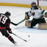 
              Minnesota Wild goaltender Marc-Andre Fleury slides across his crease as Ottawa Senators right wing Drake Batherson tries to control a bouncing pass during the second period of an NHL hockey game, Thursday, Oct. 27, 2022 in Ottawa, Ontario. (Adrian Wyld/The Canadian Press via AP)
            