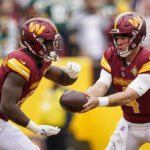
              Washington Commanders quarterback Taylor Heinicke hands the ball off to running back Brian Robinson Jr., during the first half of an NFL football game against the Green Bay Packers, Sunday, Oct. 23, 2022, in Landover, Md. (AP Photo/Patrick Semansky)
            