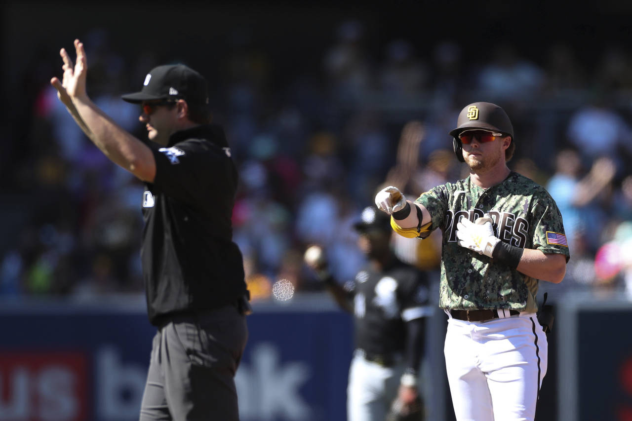 San Diego Padres' Jake Cronenworth, right, points toward the dugout after hitting a double against ...