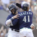 
              Seattle Mariners' Luis Torrens, back, and Carlos Santana hug after scoring on a single by Sam Haggerty during the first inning of a baseball game against the Oakland Athletics, Saturday, Oct. 1, 2022, in Seattle. (AP Photo/John Froschauer)
            