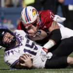 
              TCU quarterback Max Duggan (15) is tackled by Kansas defensive end Hayden Hatcher (37) during the first half of an NCAA college football game Saturday, Oct. 8, 2022, in Lawrence, Kan. (AP Photo/Charlie Riedel)
            