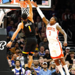 
              Phoenix Suns' Devin Booker (1) dunks past Houston Rockets' Kevin Porter Jr. (3) during the first half of an NBA basketball game, Sunday, Oct. 30, 2022, in Phoenix. (AP Photo/Darryl Webb)
            