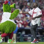 
              Former Philadelphia Phillies' Ryan Howard greets the Phill Phanatic mascot after the ceremonial first pitch before Game 4 of the baseball NL Championship Series between the San Diego Padres and the Philadelphia Phillies on Saturday, Oct. 22, 2022, in Philadelphia. (AP Photo/Matt Rourke)
            