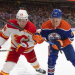 
              Calgary Flames' Michael Stone (26) and Edmonton Oilers' Jesse Puljujarvi (13) vie for the puck during the second period of an NHL hockey game Saturday, Oct. 15, 2022, in Edmonton, Alberta. (Jason Franson/The Canadian Press via AP)
            