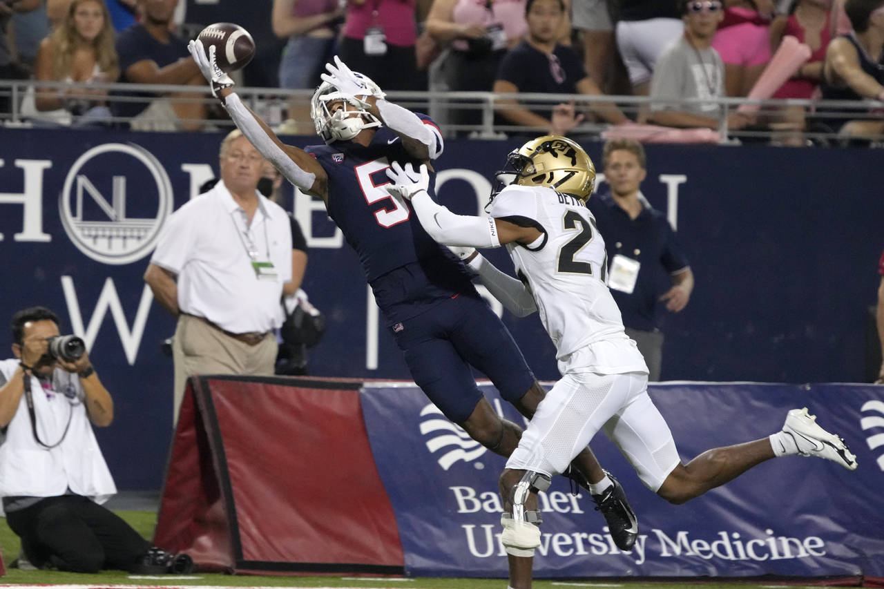 Arizona wide receiver Dorian Singer (5) makes the catch while being defended by Colorado cornerback...