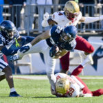 
              Connecticut running back Victor Rosa (22) is taken down by Boston College's Gunner Daniel (69) on a punt return as UConn defensive back D'Mon Brinson (20) and Boston College cornerback Jalon Williams (14) defend during the second half of an NCAA college football game at Pratt & Whitney Stadium at Rentschler Field in East Hartford, Conn., Saturday, Oct. 29, 2022. (Jessica Hill/Hartford Courant via AP)
            