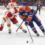 
              Calgary Flames' Nicolas Meloche (53) chases Edmonton Oilers' Connor McDavid (97) during the second period of an NHL hockey preseason game Friday, Sept. 30, 2022, in Edmonton, Alberta. (Jason Franson/The Canadian Press via AP)
            