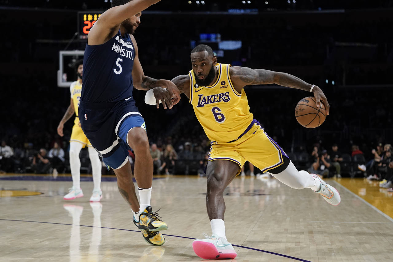 Los Angeles Lakers' LeBron James, right, drives against Minnesota Timberwolves' Kyle Anderson durin...