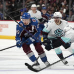 
              Colorado Avalanche center Nathan MacKinnon, left, pursues the puck with Seattle Kraken center Alex Wennberg (21) and defenseman Will Borgen during the first period of an NHL hockey game Friday, Oct. 21, 2022, in Denver. (AP Photo/David Zalubowski)
            