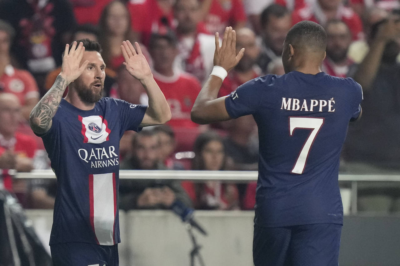 PSG's Lionel Messi, left, celebrates with PSG's Kylian Mbappe after scoring during the Champions Le...