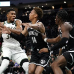 
              Milwaukee Bucks' Giannis Antetokounmpo, left, drives to the basket against Brooklyn Nets' Kessler Edwards (14) during the second half of an NBA preseason basketball game Wednesday, Oct. 12, 2022, in Milwaukee. (AP Photo/Aaron Gash)
            