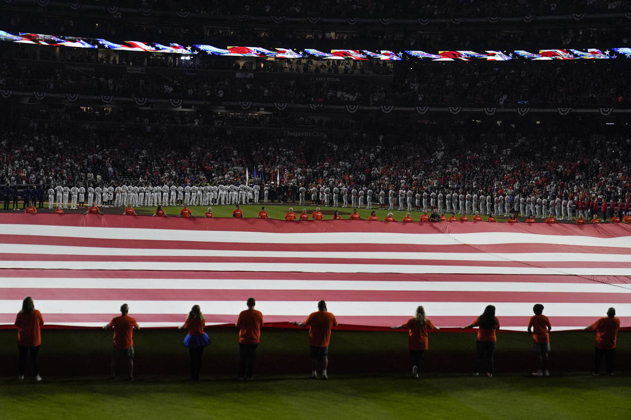 The American flag is unfurled during the national anthem beforeGame 1 of baseball's World Series be...