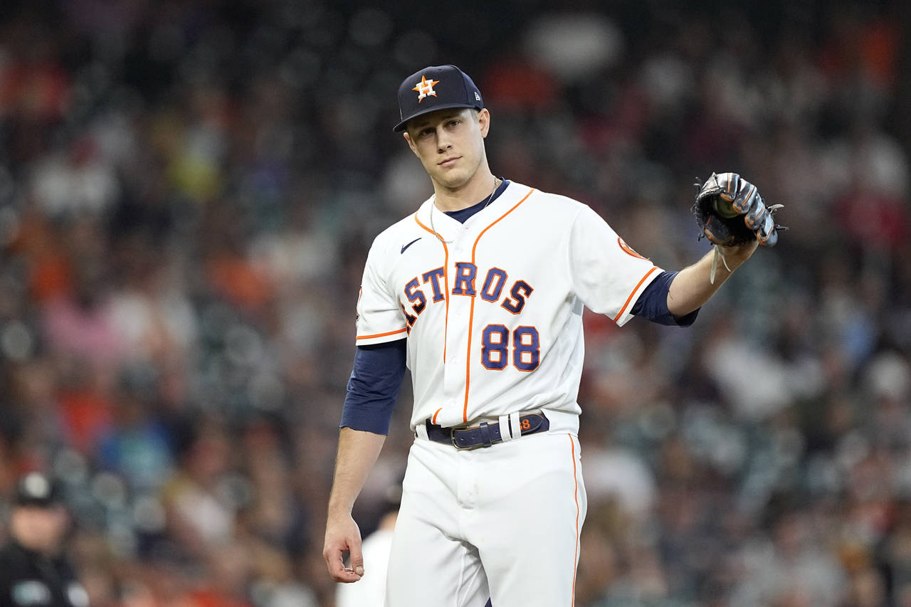 Houston Astros relief pitcher Phil Maton looks toward first base after giving up a single to his br...