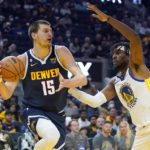
              Denver Nuggets center Nikola Jokic (15) looks to pass the ball against Golden State Warriors center Kevon Looney (5) during the first half of an NBA preseason basketball game in San Francisco, Friday, Oct. 14, 2022. (AP Photo/Jeff Chiu)
            