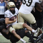 
              Wake Forest quarterback Sam Hartman (10) is sacked by Louisville defensive back Kei'Trel Clark (13) during the first half of an NCAA college football game in Louisville, Ky., Saturday, Oct. 29, 2022. (AP Photo/Timothy D. Easley)
            