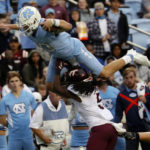 
              FILE - North Carolina quarterback Drake Maye (10) sails over Virginia Tech defensive back Nasir Peoples (5) during the second half of an NCAA college football game in Chapel Hill, N.C., Saturday, Oct. 1, 2022. Maye was selected the top offensive player in the Associated Press ACC Midseason Awards, Wednesday, Oct. 12, 2022.(AP Photo/Chris Seward, File)
            