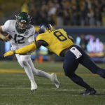 
              Baylor quarterback Blake Shapen (12) tries to get past West Virginia linebacker Lee Kpogba (8) during the first half of an NCAA college football game in Morgantown, W.Va., Thursday, Oct. 13, 2022. (AP Photo/Kathleen Batten)
            