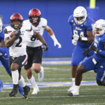 
              Cincinnati's Corey Kiner runs away from Tulsa defenders during the first half of an NCAA college football game in Tulsa, Okla., Saturday, Oct. 1, 2022. (AP Photo/Dave Crenshaw)
            