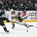 
              Vegas Golden Knights defenseman Alec Martinez and Seattle Kraken right wing Oliver Bjorkstrand reach for the puck during the second period of an NHL hockey game Saturday, Oct. 15, 2022, in Seattle. (AP Photo/Jason Redmond)
            