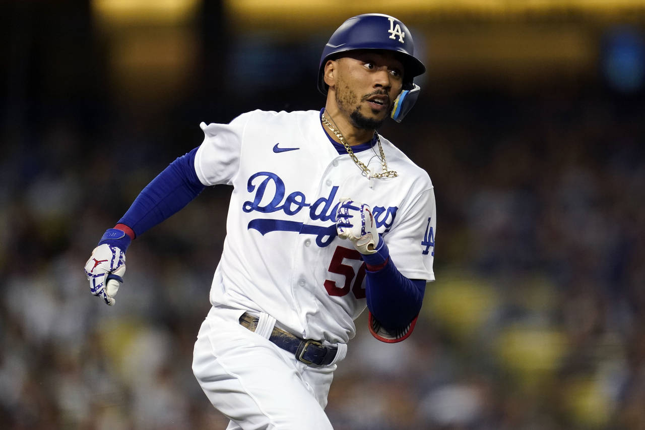 Los Angeles Dodgers' Mookie Betts rounds first base as he doubles during the third inning of a base...