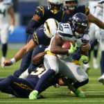 
              Seattle Seahawks running back DeeJay Dallas (31) is tackled by Los Angeles Chargers cornerback Ja'Sir Taylor (36) and long snapper Josh Harris (47) during the first half of an NFL football game Sunday, Oct. 23, 2022, in Inglewood, Calif. (AP Photo/Marcio Jose Sanchez)
            