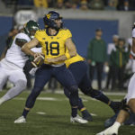 
              West Virginia quarterback JT Daniels (18) looks for a receiver during the first half of the team's NCAA college football game against Baylor in Morgantown, W.Va., Thursday, Oct. 13, 2022. (AP Photo/Kathleen Batten)
            