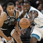 
              Charlotte Hornets' Terry Rozier, right, and San Antonio Spurs' Keldon Johnson vie for possession of the ball during the first half of an NBA basketball game Wednesday, Oct. 19, 2022, in San Antonio. (AP Photo/Darren Abate)
            