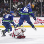 
              Vancouver Canucks' Nils Aman (88), of Sweden, leaps over Carolina Hurricanes' Brady Skjei (76) during the second period of an NHL hockey game in Vancouver, British Columbia, on Monday, Oct. 24, 2022. (Darryl Dyck/The Canadian Press via AP)
            