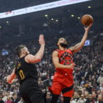 
              Toronto Raptors guard Fred VanVleet (23) lays up the ball while defended by Cleveland Cavaliers forward Kevin Love (0) during the first half of an NBA basketball game Wednesday, Oct. 19, 2022, in Toronto. (Christopher Katsarov/The Canadian Press via AP)
            