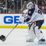 
              Columbus Blue Jackets goaltender Elvis Merzlikins (90) returns the helmet of New Jersey Devils left wing Miles Wood (44) after Wood was hit by a stick during the third period of an NHL hockey game Sunday, Oct. 30, 2022, in Newark, N.J. (AP Photo/Eduardo Munoz Alvarez)
            