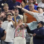 
              Fans reach for a foul ball by New York Yankees' Aaron Judge during the second inning in the second baseball game of a doubleheader against the Texas Rangers in Arlington, Texas, Tuesday, Oct. 4, 2022. (AP Photo/LM Otero)
            