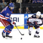 
              New York Rangers center Mika Zibanejad (93) plays the puck against Columbus Blue Jackets defenseman Nick Blankenburg (77) during the first period of an NHL hockey game, Sunday, Oct. 23, 2022, in New York. (AP Photo/Noah K. Murray)
            