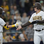 
              San Diego Padres' Brandon Dixon, right, celebrates with teammate Jake Cronenworth after scoring off a walk with the bases loaded by Josh Bell during the eighth inning of a baseball game against the San Francisco Giants, Monday, Oct. 3, 2022, in San Diego. (AP Photo/Gregory Bull)
            