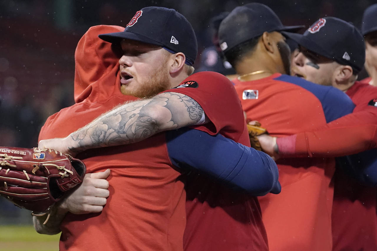 Boston Red Sox's Alex Verdugo, front right, and teammates embrace following the team's final regula...