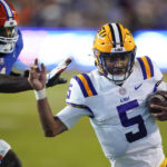 
              LSU quarterback Jayden Daniels (5) slips by Florida linebacker Brenton Cox Jr. for a 9-yard touchdown run during the second half of an NCAA college football game, Saturday, Oct. 15, 2022, in Gainesville, Fla. (AP Photo/John Raoux)
            