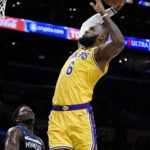 
              Los Angeles Lakers' LeBron James goes up for a dunk as Minnesota Timberwolves' Anthony Edwards watches during first half of an NBA preseason basketball game Wednesday, Oct. 12, 2022, in Los Angeles. (AP Photo/Jae C. Hong)
            