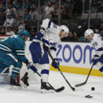 
              San Jose Sharks defenseman Matt Benning, left, reaches for the puck against the Tampa Bay Lightning left wing Cole Koepke (45), center, and center Ross Colton (79) in the second period of an NHL hockey game, Saturday, Oct. 29, 2022, in San Jose, Calif., Saturday, Oct. 29, 2022. (AP Photo/Josie Lepe)
            
