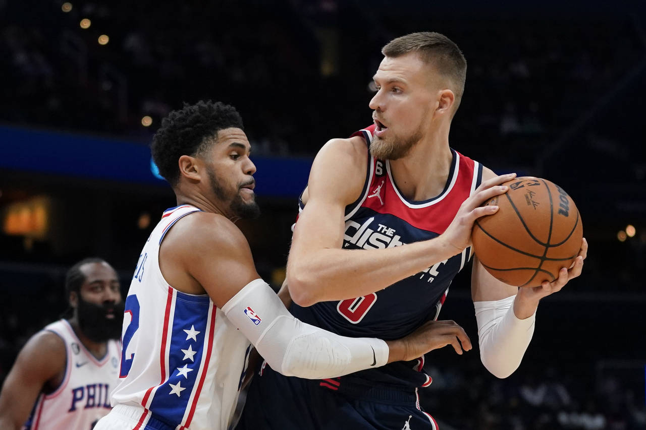 Washington Wizards center Kristaps Porzingis, right, of Latvia, protects the ball as he is pressure...